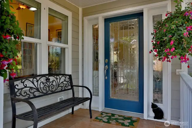 Covered main entry porch with custom glass door.