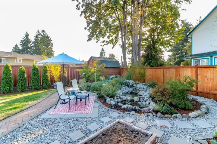 Peaceful water feature with lights provides a relaxing space all year long. Large storage shed with workbench.