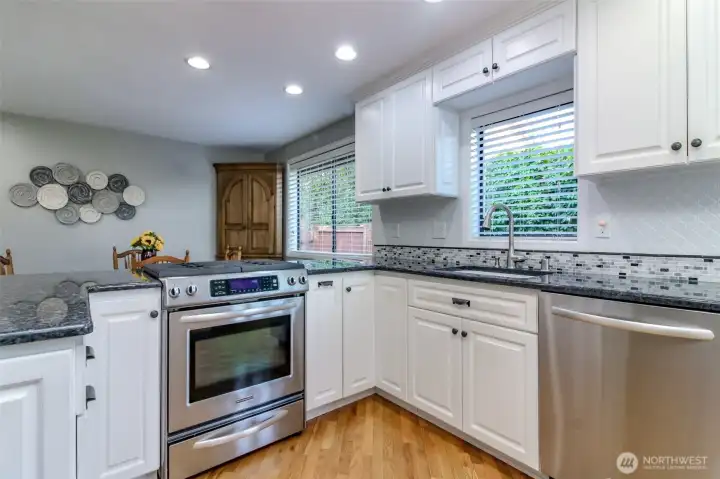 Open kitchen sparkles with custom cabinets, granite countertops.