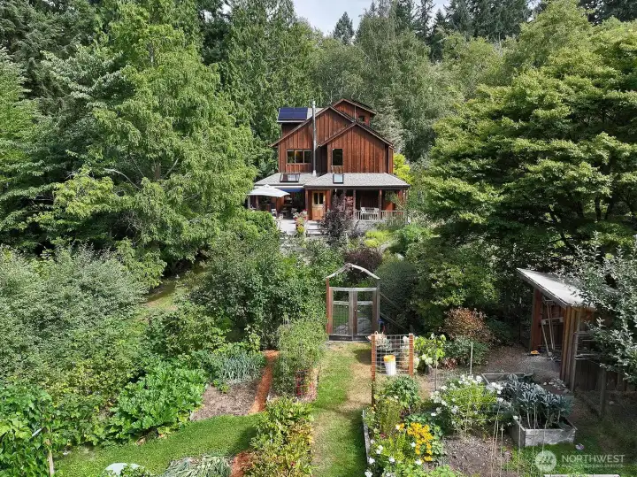 Classic Northwest Maxwelton Valley home on a sunny perch surrounded by forested acreage with gardens and a trail to miles of public trails on The Chinook lands of The Whidbey Institute and the Whidbey Island Waldorf School.