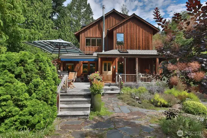 Expansive deck with a sweet covered porch that wraps around to your mud room (side entrance) with laundry and half bath. The main door is straight ahead up the stairs to the left of your deck.