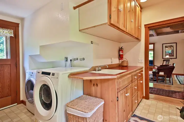 We are back at the front of the home to the walk through laundry and mud room adjacent to the Living Room and also accessible from the covered porch (door along left edge of photo). There is a half bath to your back (next photo).