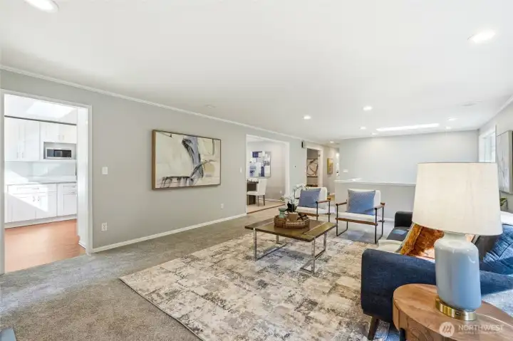 Open Concept Living Room with Skylight and Seamless Flow to Kitchen and Dining