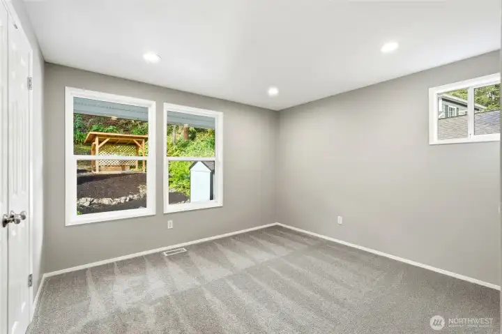 Bedroom 2 with Large Windows and Peaceful Backyard Views
