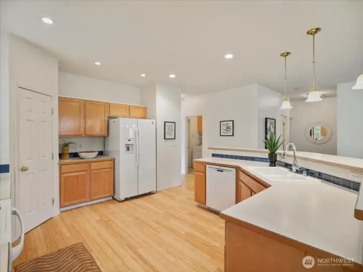 Another view of the kitchen showcasing a warm and inviting feel with coordinated maple cabinetry and Bamboo flooring.