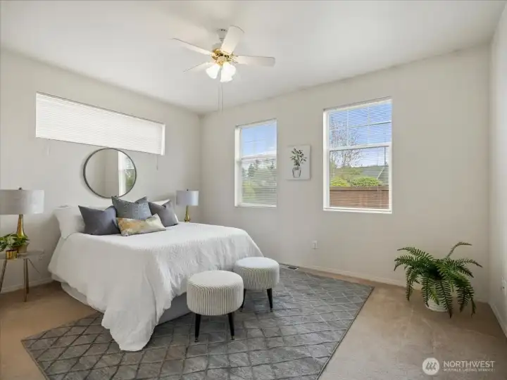Serene Primary bedroom offering a ceiling fan and beautiful windows that fill the space with natural light.