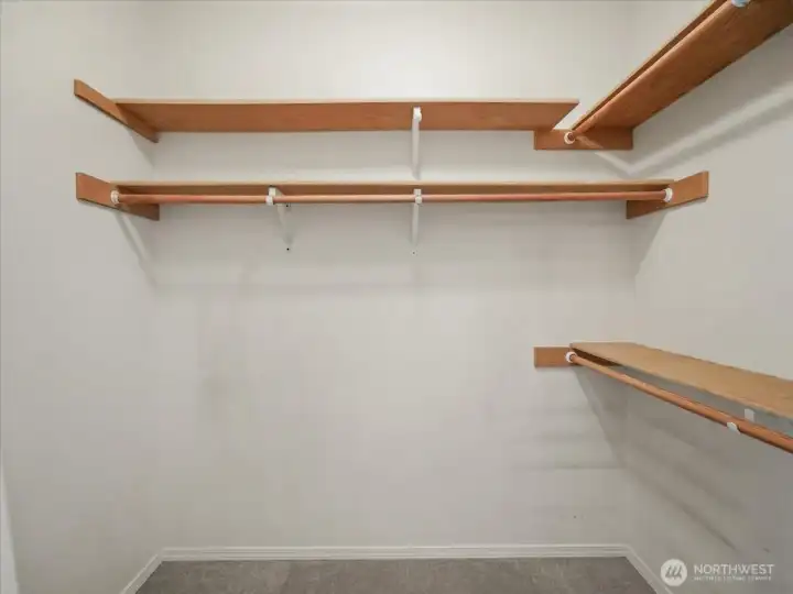 Walk-in closet has built-ins shelving for organized efficient storage.