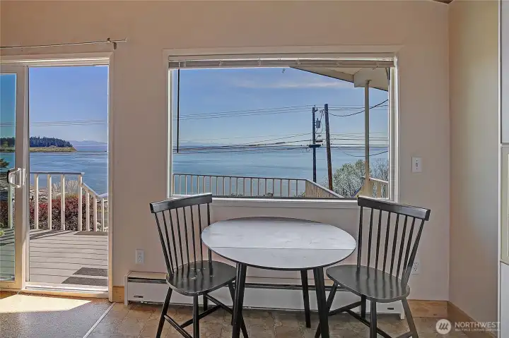 Dining area with large picture window capturing water views and natural light.