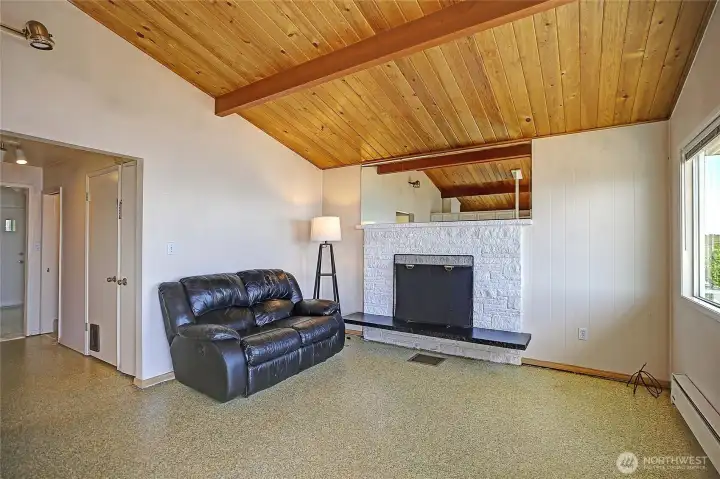 Inviting living space with vaulted ceilings and fireplace, perfect for relaxing or entertaining.