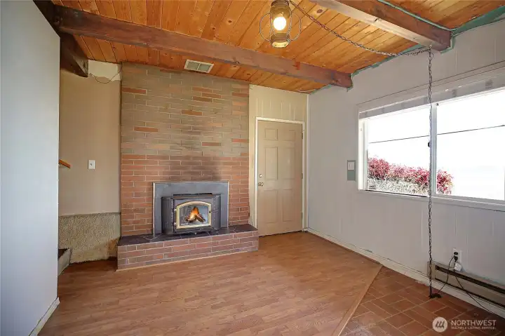 Lower level living area with wood stove, offering great potential for customization.