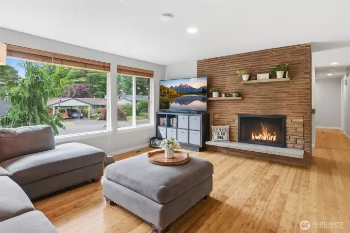 Upstairs living room with wall to wall west facing windows and cozy wood burning fireplace.