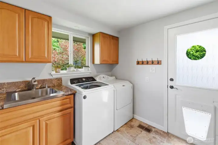 Laundry off the kitchen in the mud room, with a half bath and extra refrigerator and access to the South facing yard.