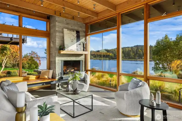 A deep built-in bench and sculptural steel-and-concrete fireplace form the heart of the room.