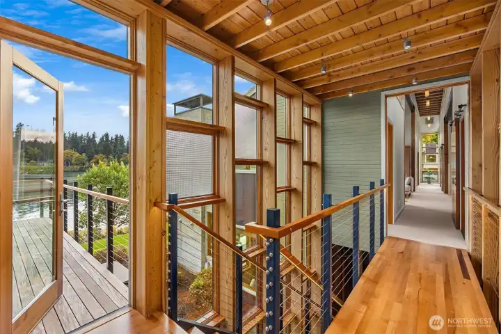 The upstairs landing opens to an ipe waterside deck adjacent to the primary bedroom suite.