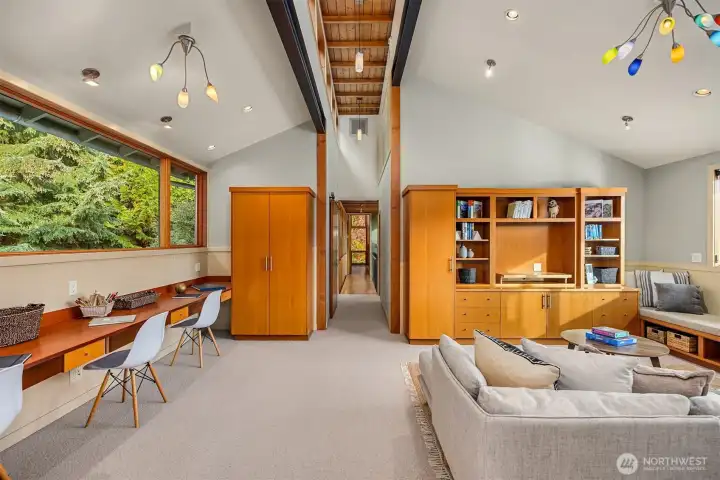 From the upper floor landing, a walkway leads from the primary suite to a separate bedroom wing with media/family room, utility room, three bedrooms and two full bathrooms.