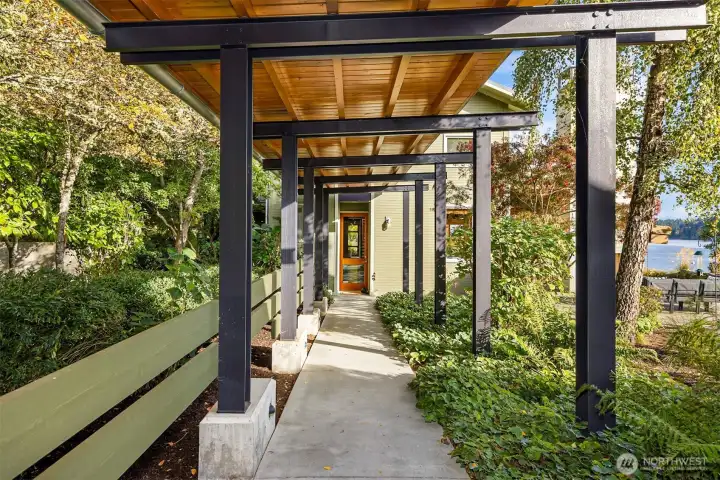 A covered breezeway connects the home with the detached guest space/studio and garage.