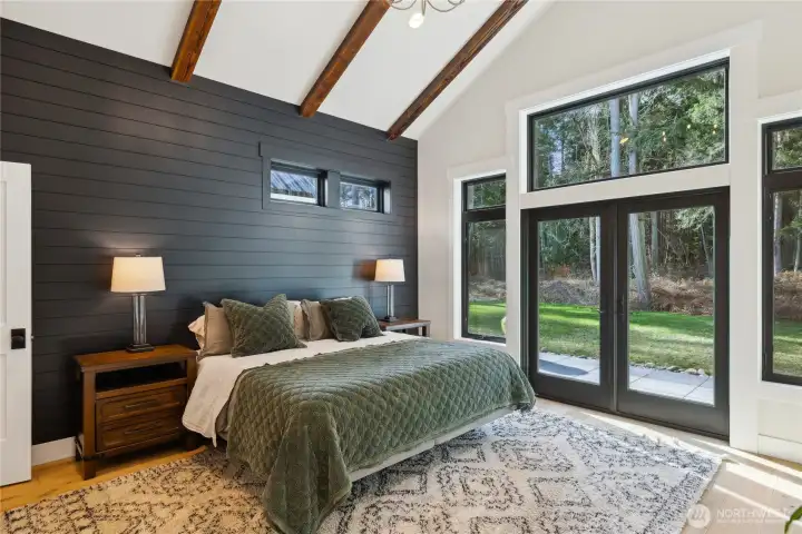 Primary suite with vaulted, beamed ceiling and sliding door to the beautiful backyard.