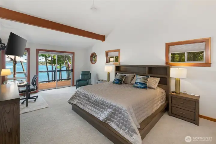 Primary suite offers generous space, vaulted ceiling detail, deck access, and beautiful waterfront views, creating a peaceful retreat within this San Juan Island home.