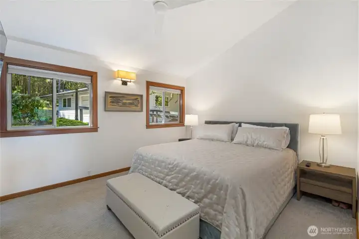Inviting guest bedroom with vaulted ceiling, natural light, and a peaceful forested outlook, ideal for hosting visitors at this San Juan Island waterfront retreat.
