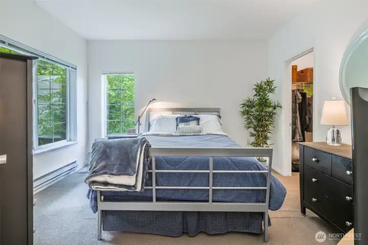 Primary bedroom is spacious and bright with the windows showing a view of the forest Primary bedroom is spacious and bright with the windows showing a view of the forest
