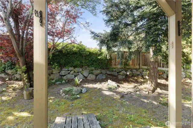 Covered concrete patio for BBQ or plant a small garden.  Very attractive area
