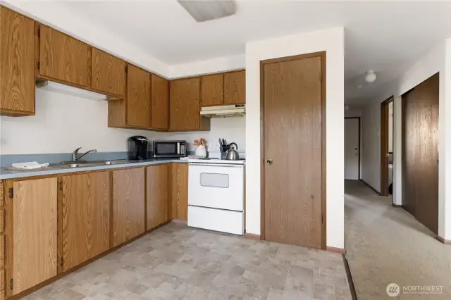 Kitchen is open and bright.  White door on the far right is the front entrance.  The large closet on the right is the coat closet and a big linen, books, games whatever closet
