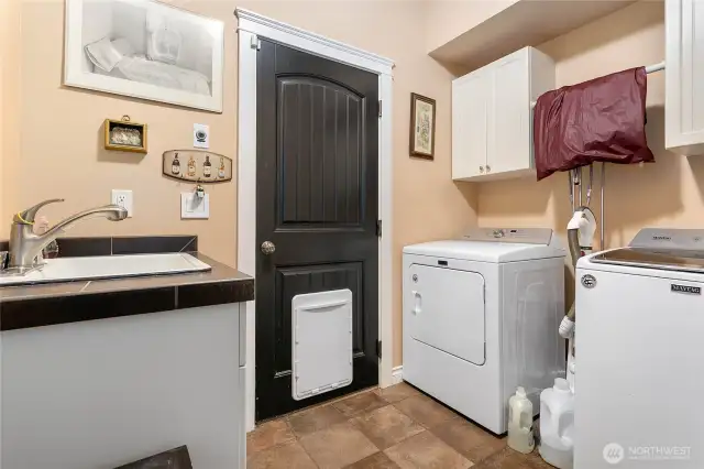 Shared (for now) utility area with storage, washer/dryer, and utility sink.