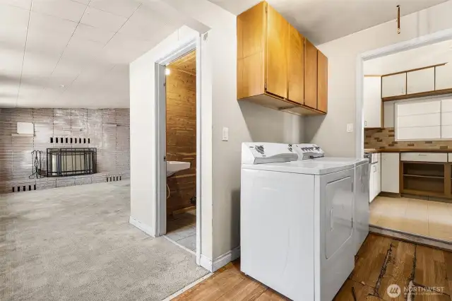 Family room, half bath, and laundry area are off the kitchen.  Access to the garage is across from the dryer on the right edge of the photo.  The flooring in front of the washer and dryer may have been laid over vinyl.