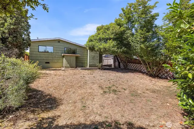 Generous back yard is fully fenced.  The two windows you see are both to bedrooms.
