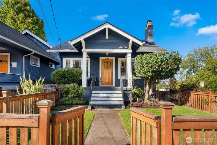 Classic craftsman with crisp navy paint and white trim, welcoming front porch, and warm wood door creates timeless curb appeal.