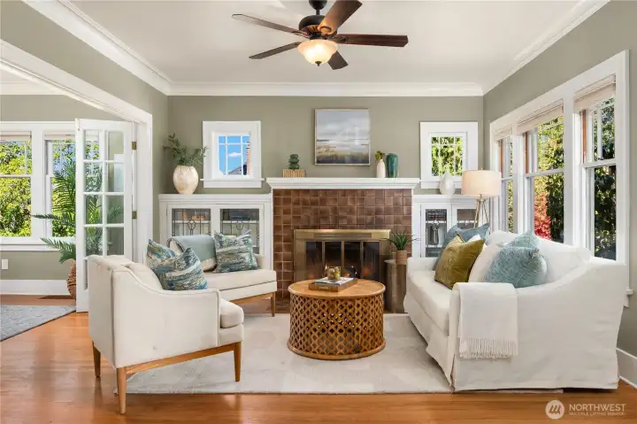 Anchored by a striking fireplace with built-ins, this airy living room features expansive windows that fill the space with sunshine.
