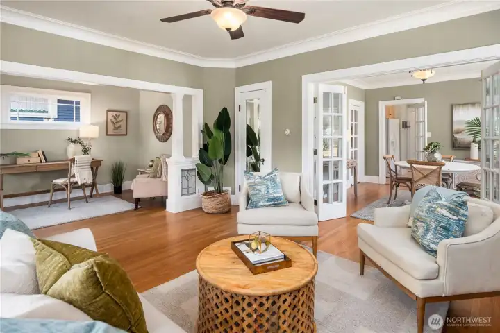 Elegant red oak hardwoods and French doors guide the eye toward the dining space, making gatherings both stylish and effortless.