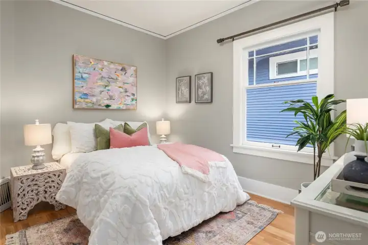 A cheerful second bedroom with fresh finishes, soft neutral tones, and natural light makes a welcoming guest or family space.