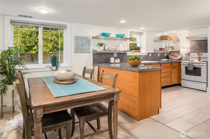 The lower level offers its own stylish kitchen and dining area, complete with granite counters, open shelving, and a bright windowed nook.