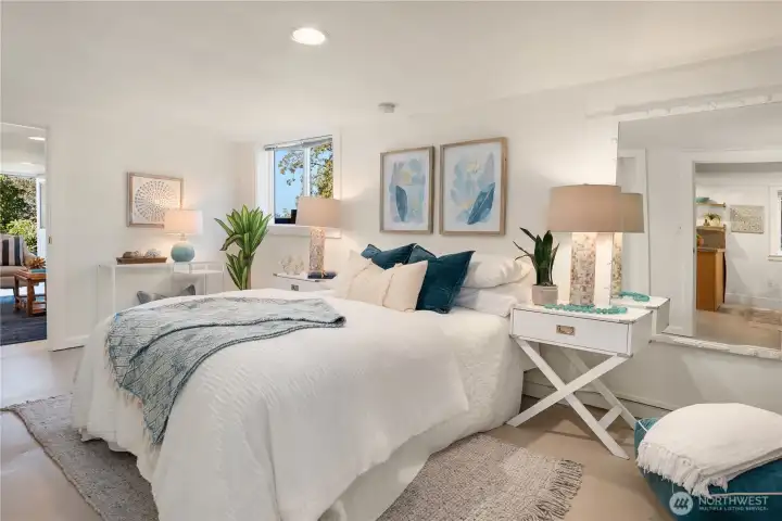 A spacious lower-level bedroom serves as a serene retreat, enhanced by soft lighting, fresh finishes, and garden-level windows.