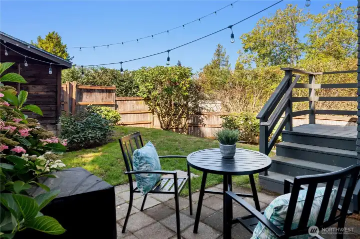 A private patio space under string lights is perfect for alfresco dining or summer evenings with friends.