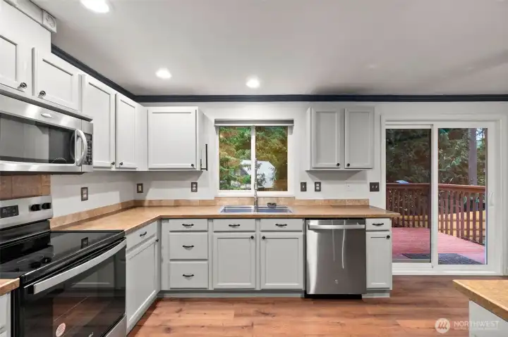 Canned lighting and large window over sink looking out to your fully fenced backyard.