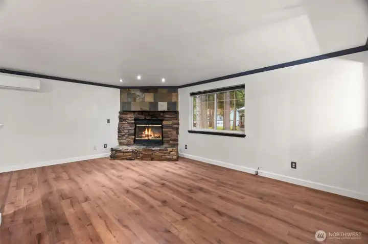 Wood burning fireplace in living room with stone accents.