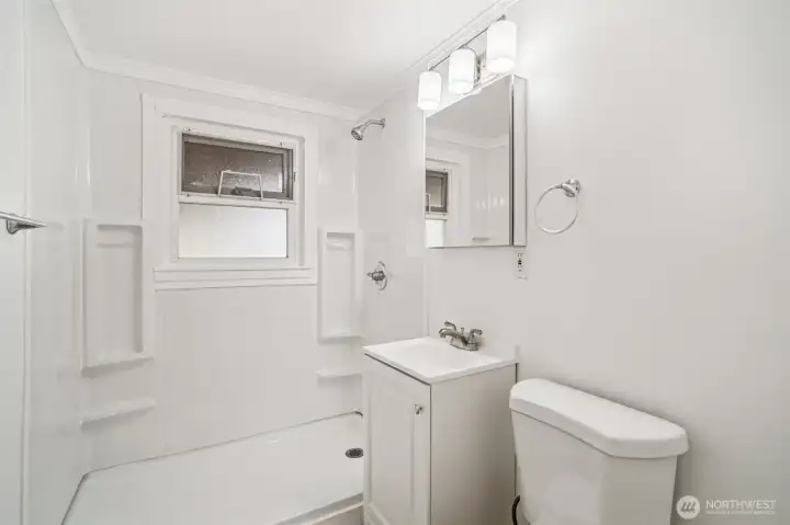 Renovated bath with new shower pan, shower surround, vanity, toilet and fixtures