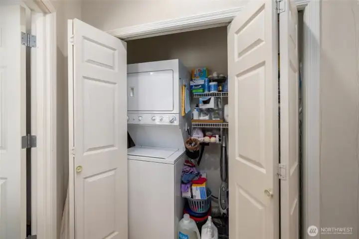 laundry closet in the hall with stackable washer and dryer