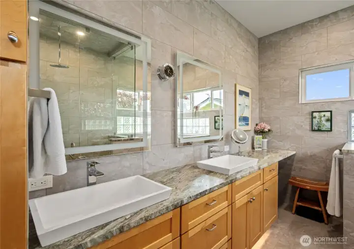 Primary bath with expansive double vanity, with illuminated mirrors, heated flooring. Primary bath with expansive double vanity, with illuminated mirrors, heated flooring.