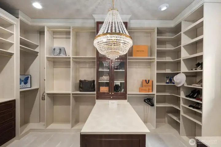 The primary suite walk-in closet is thoughtfully designed with tailored organization and refined finishes, offering an elegant space to store and display wardrobes with ease. Custom layout and attention to detail create a functional yet elevated environment that complements the sophistication of the primary retreat.