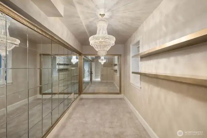 An additional lower-level room offers a striking architectural presence with reflective surfaces and abundant light, creating a dramatic, gallery-like atmosphere reminiscent of a grand European hall. The space provides a versatile setting well-suited for entertaining, display, fitness, or flexible use, depending on lifestyle needs.