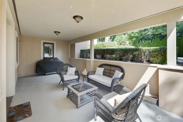 A covered patio extends directly from the secondary kitchen and lower-level living area, creating a seamless indoor-outdoor connection ideal for extended living and entertaining. This protected outdoor space offers year-round usability, providing shade in summer and shelter during cooler, wetter months, while maintaining easy access to the interior kitchen and living areas.