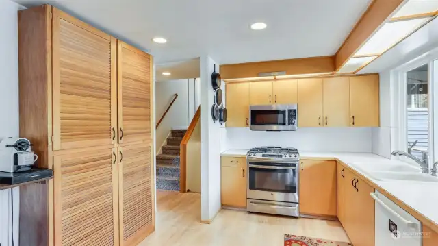 The kitchen is open and light & bright with tons of cabinet space, plus this built-on pantry storage.