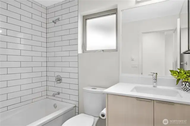 Bathroom off 2nd and 3rd bedroom lower floor. White subway tile light and bright.
