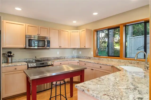 The seller loves watching the birds outside her kitchen windows. This duplex-style end-unit is private and surrounded by beauty inside and out. The island work table does not convey but can easily be replaced with your own style of a work table.