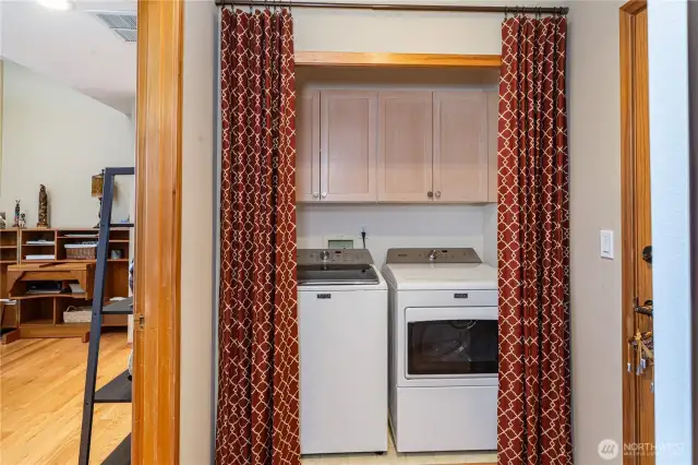 The utility closet includes the newer washer and dryer and more storage space. The door to the left leads to the garage. Functionality reigns in this lovely home!