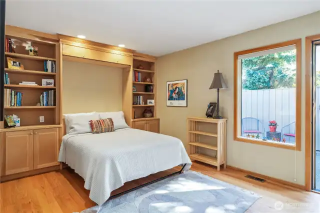 The guest bedroom has a wonderful built-in murphy-style bed and shelving. Great guest space, home-office, library, or whatever you like. Note the hardwood floors, and access to the fenced patio outside.