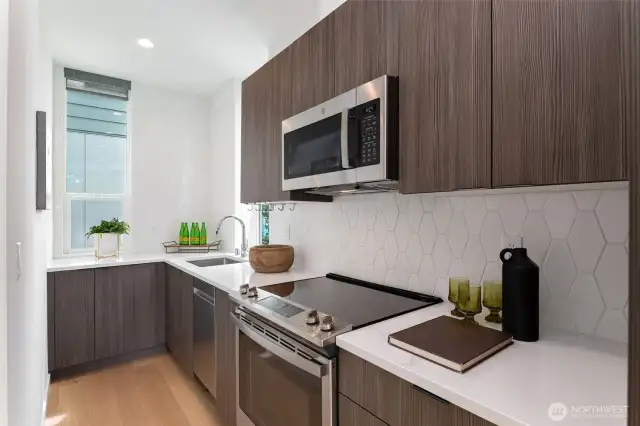 Sleek, modern kitchen with custom cabinetry, quartz countertops, and stainless steel appliances.